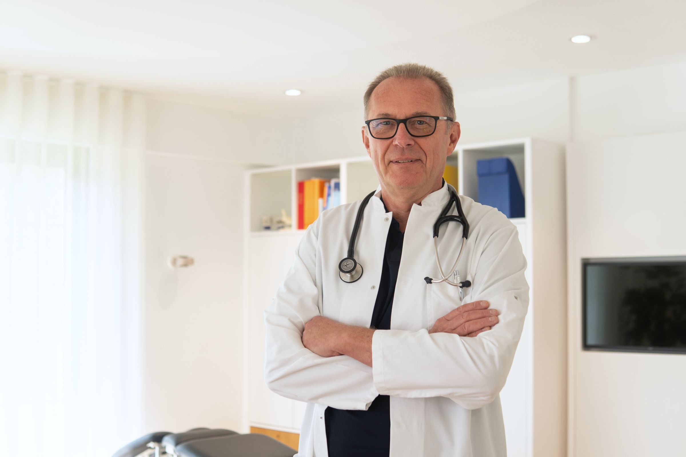 Dr. Stefan Balzer im weißen Kittel in seinem Sprechzimmer